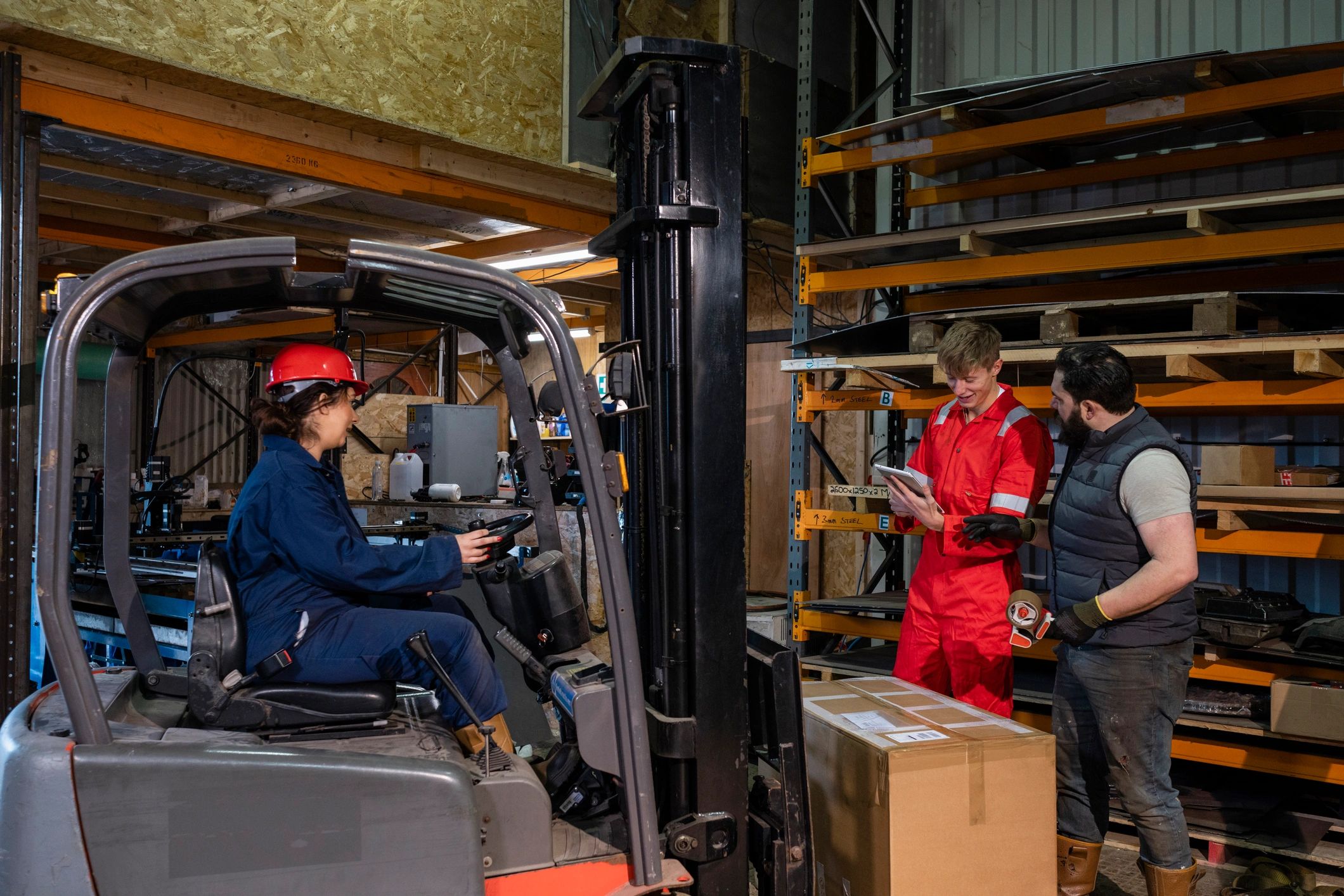 Manufacturing shop floor with inventory, forklift activity, and digital coordination